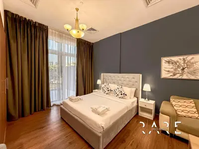 a bedroom with a bed and a large window at Rare Holiday Homes - Near Miracle Garden - Lavender 2 - RG012 - Jumeirah Village Circle in Dubai