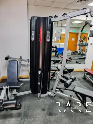 a gym with several treadmills and machines at Rare Holiday Homes - Near Miracle Garden - Lavender 2 - RG012 - Jumeirah Village Circle in Dubai