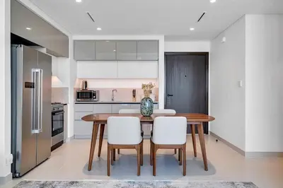 a kitchen with a wooden table and white chairs at Dubai Marina Harbour View 2BR with Beach Access in Dubai