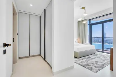 a bedroom with a bed and a large window at Dubai Marina Harbour View 2BR with Beach Access in Dubai