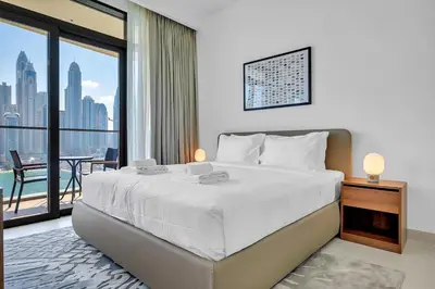 a bedroom with a large bed with a view of the city at Dubai Marina Harbour View 2BR with Beach Access in Dubai