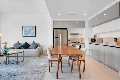 a kitchen and living room with a table and chairs at Dubai Marina Harbour View 2BR with Beach Access in Dubai