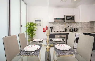 a dining room with a table and chairs in a kitchen at Homesgetaway -Spacious 1BR Apt in Pearlz by Danube in Dubai