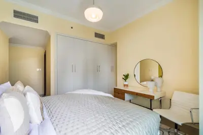 a bedroom with a white bed and a mirror at The Smart Concierge - Time Place in Dubai