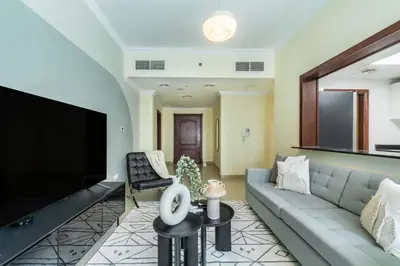 a living room with a couch and a flat screen tv at The Smart Concierge - Time Place in Dubai