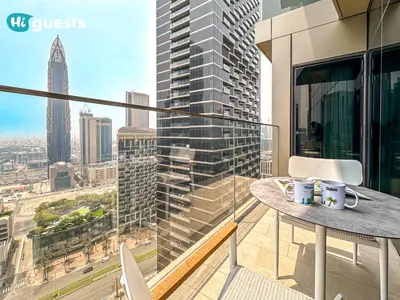 a balcony with a table and chairs and a view of a city at HiGuests - Sky-High Experience Luxe Living on the 24th Floor in Dubai