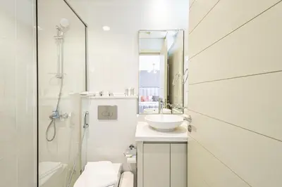a white bathroom with a sink and a shower at Luxury 3BR 2storey Villa with Garden in Damac Hills in Dubai