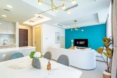 a kitchen and living room with a blue wall at Luxury 3BR 2storey Villa with Garden in Damac Hills in Dubai