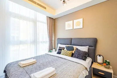 a bedroom with a bed with pillows and a window at Luxury 3BR 2storey Villa with Garden in Damac Hills in Dubai