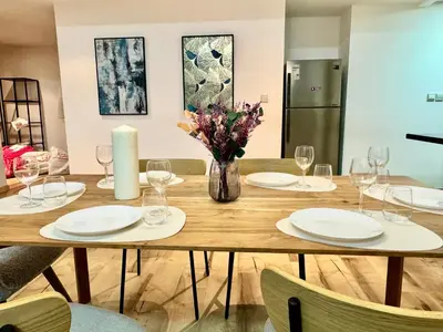 a dining room table with glasses and a candle at Stylish beachside apartment 3 beds in JBR in Dubai
