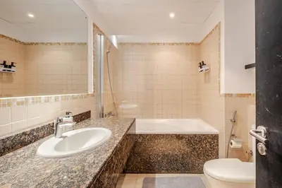 a bathroom with a sink and a tub and a toilet at Stylish beachside apartment 3 beds in JBR in Dubai