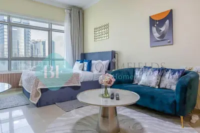 a living room with a blue couch and a table at Bloomfields Deluxe Stu Jlt Near Metro in Dubai