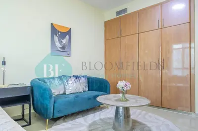 a living room with a blue couch and a table at Bloomfields Deluxe Stu Jlt Near Metro in Dubai