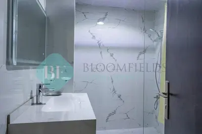 a bathroom with a sink and a mirror at Bloomfields Deluxe Stu Jlt Near Metro in Dubai