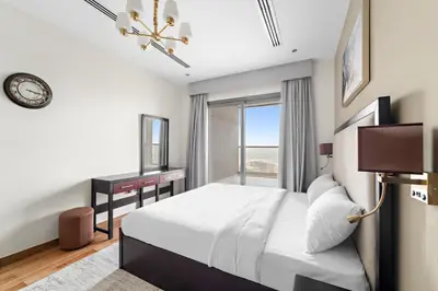 a bedroom with a bed and a desk and a window at Big 1 bedroom close to Downtown in Dubai