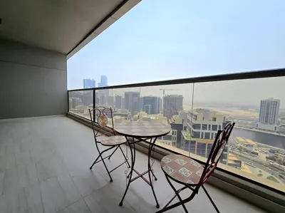 a balcony with a table and chairs and a large window at Big 1 bedroom close to Downtown in Dubai