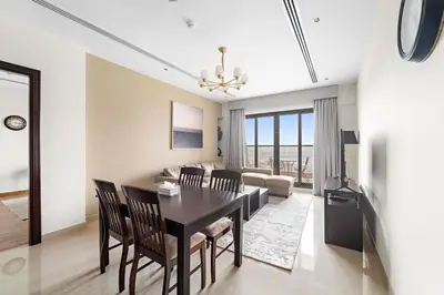 a dining room and living room with a table and chairs at Big 1 bedroom close to Downtown in Dubai