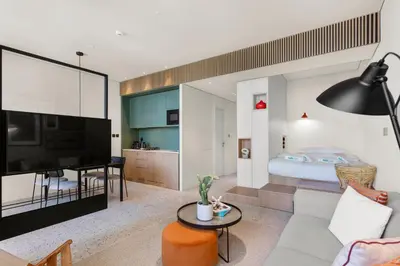a living room with a large television and a bedroom at Stylish Studio in Upside Living with Top Amenities in Dubai
