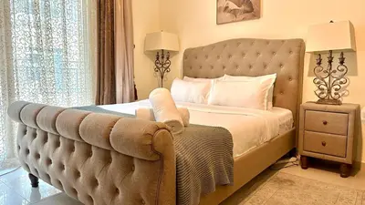 a bedroom with a bed with a tufted headboard at Charming Studio Retreat in Central JVC by Bhavan Vacation Homes in Dubai