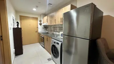 a kitchen with a stainless steel refrigerator and a dishwasher at Charming Studio Retreat in Central JVC by Bhavan Vacation Homes in Dubai