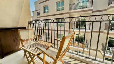 two chairs sitting on the balcony of a building at Charming Studio Retreat in Central JVC by Bhavan Vacation Homes in Dubai
