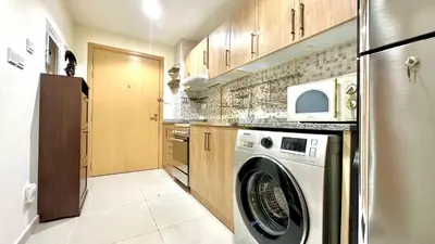 a kitchen with a washing machine and a refrigerator at Charming Studio Retreat in Central JVC by Bhavan Vacation Homes in Dubai