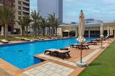 a large swimming pool with umbrellas and chairs and a pool at Manzil - 2BR Home with Waterfront Views in Palm in Dubai