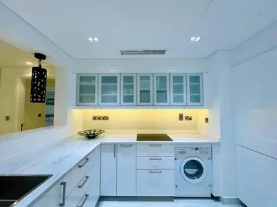 a white laundry room with a washer and dryer at Manzil - 2BR Home with Waterfront Views in Palm in Dubai