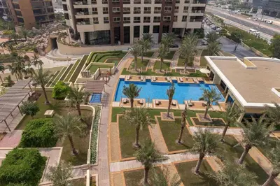 an aerial view of a resort with a pool and palm trees at Manzil - 2BR Home with Waterfront Views in Palm in Dubai