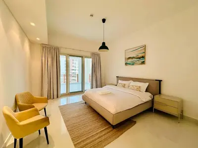 a bedroom with a bed and a chair in it at Manzil - 2BR Home with Waterfront Views in Palm in Dubai