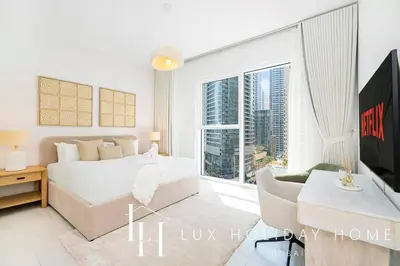 a bedroom with a bed and a large window at LUX The JBR Garden View Suite in Dubai