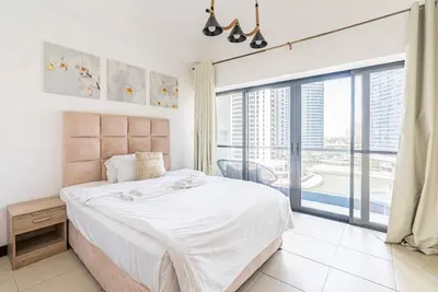 a bedroom with a large bed and a large window at Amazing lake skyline view cozy apartment in Dubai