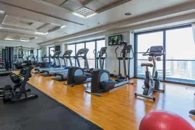 a gym with a bunch of treadmills and ellipticals at Amazing lake skyline view cozy apartment in Dubai