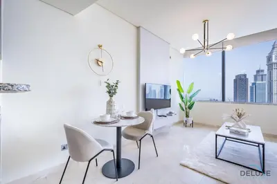 a white living room with a table and chairs at Exclusive Studio at Sky Gardens, DIFC by Deluxe Holiday Homes in Dubai
