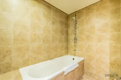 a bath tub in a bathroom with tiled walls at Exclusive Studio at Sky Gardens, DIFC by Deluxe Holiday Homes in Dubai