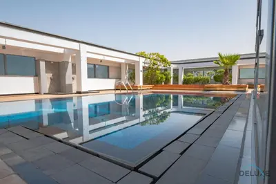a swimming pool in front of a house at Exclusive Studio at Sky Gardens, DIFC by Deluxe Holiday Homes in Dubai