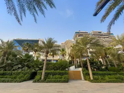 a large building with palm trees in front of it at Five Palm Luxury - 2BR with Pool View, Gym & Prime Beach Stay in Dubai