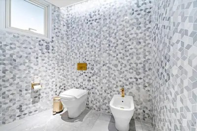 a bathroom with a toilet and a sink at Five Palm Luxury - 2BR with Pool View, Gym & Prime Beach Stay in Dubai