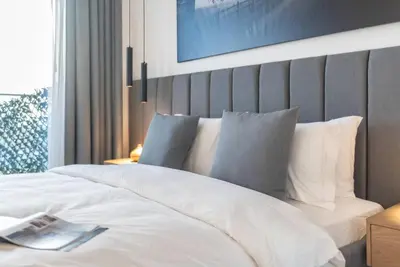 a bedroom with a large bed with white sheets and pillows at Stylish 3BR Apartment in Dubai Marina with Pool, Gym, and Views in Dubai