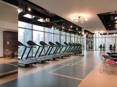 a gym with rows of treadmills in a building at Stylish 3BR Apartment in Dubai Marina with Pool, Gym, and Views in Dubai