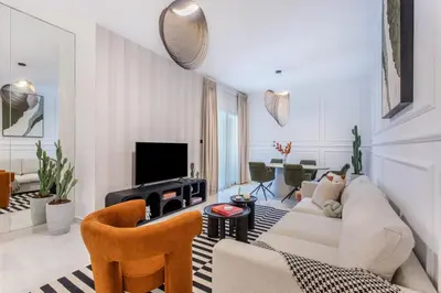 a living room with a couch and chairs and a tv at Comfy 1BR Marina Living Steps from Marina Walk in Dubai