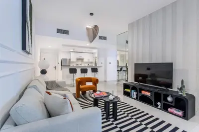 a living room with a couch and a tv at Comfy 1BR Marina Living Steps from Marina Walk in Dubai