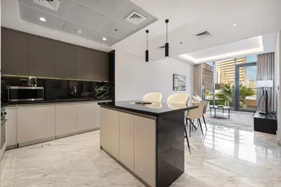 a kitchen with white cabinets and a black counter top at Upscale 2BR with Private Terrace & Pool View in Dubai