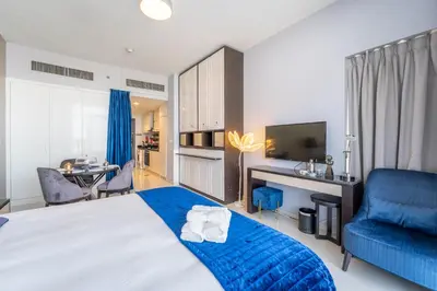 a bedroom with a blue bed and a blue chair at Stylish Studio with Pool View & Free Parking in Dubai