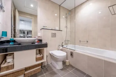 a bathroom with a toilet and a sink and a bath tub at Stylish Studio with Pool View & Free Parking in Dubai