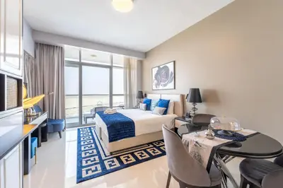 a hotel room with a bed and a table and chairs at Stylish Studio with Pool View & Free Parking in Dubai
