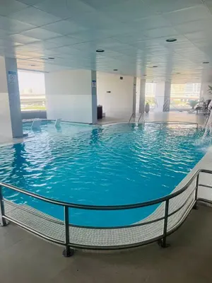 a large swimming pool in a large building at Stunning Panoramic Sea & Marina City Skyline View in Dubai