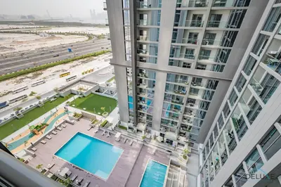 an aerial view of a building with a swimming pool at Charming 1BR Apartment in Sobha Creek Vistas Reserve, Al Merkadh by Deluxe Holiday Homes in Dubai