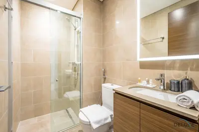 a bathroom with a shower and a toilet and a sink at Charming 1BR Apartment in Sobha Creek Vistas Reserve, Al Merkadh by Deluxe Holiday Homes in Dubai