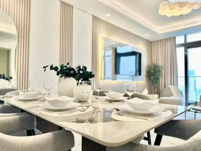 a dining room with a white table and chairs at 64th Floor Highest Downtown Infinity Pool Burj Khalifa View in Dubai